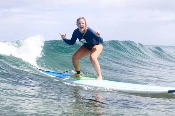 a woman riding a wave on a surfboard in the water