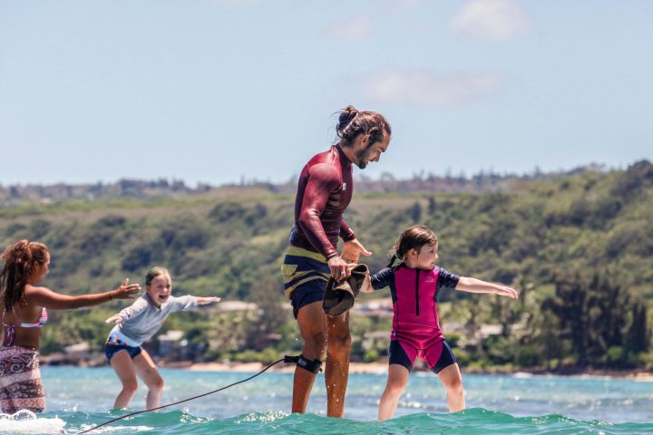 a group of people riding surfboards on a body of water