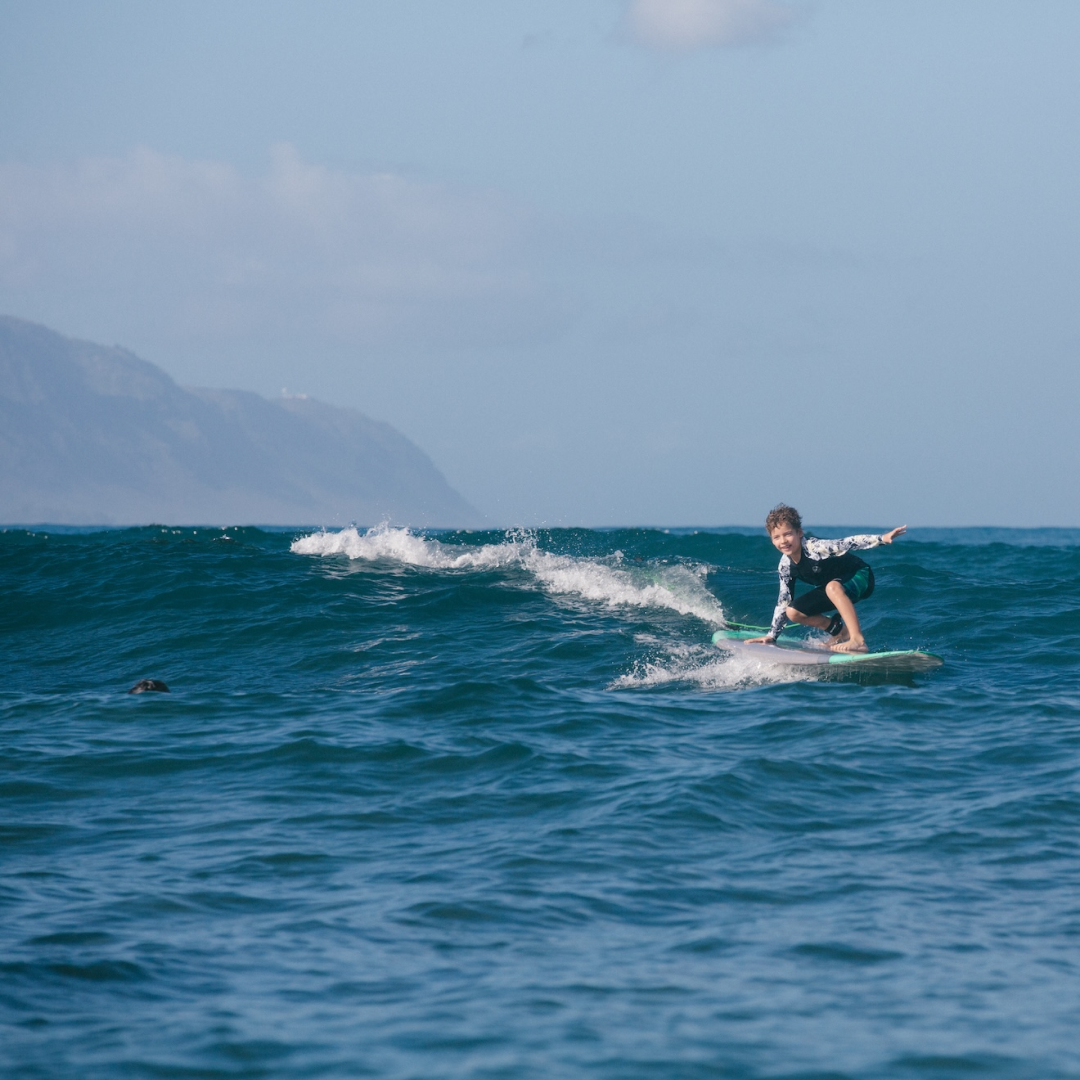 Beginner Kid riding a surf in Oahu